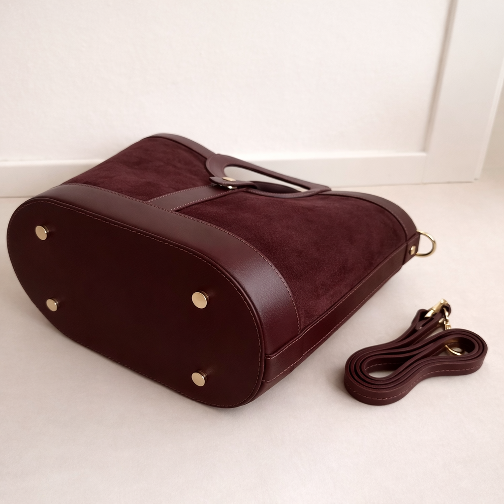 Gros plan texture daim et cuir de veau lisse bordeaux du sac Gabrielle, artisanat florentin