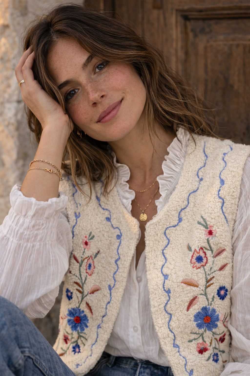  Femme portant le gilet Julia sherpa brodé avec chemisier blanc - style bohème chic