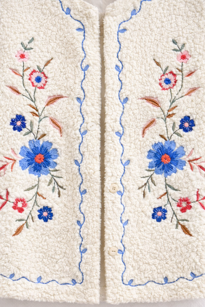  Détail des broderies délicates sur le gilet Julia en sherpa écru